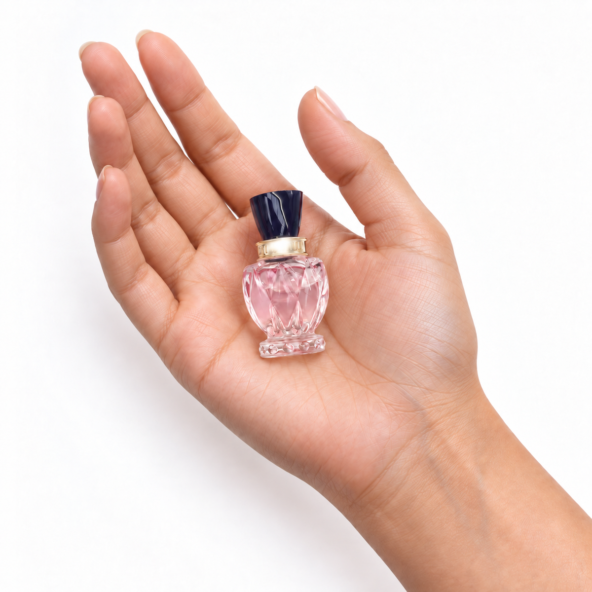 Blush Current 5ml miniature resting in a palm on white