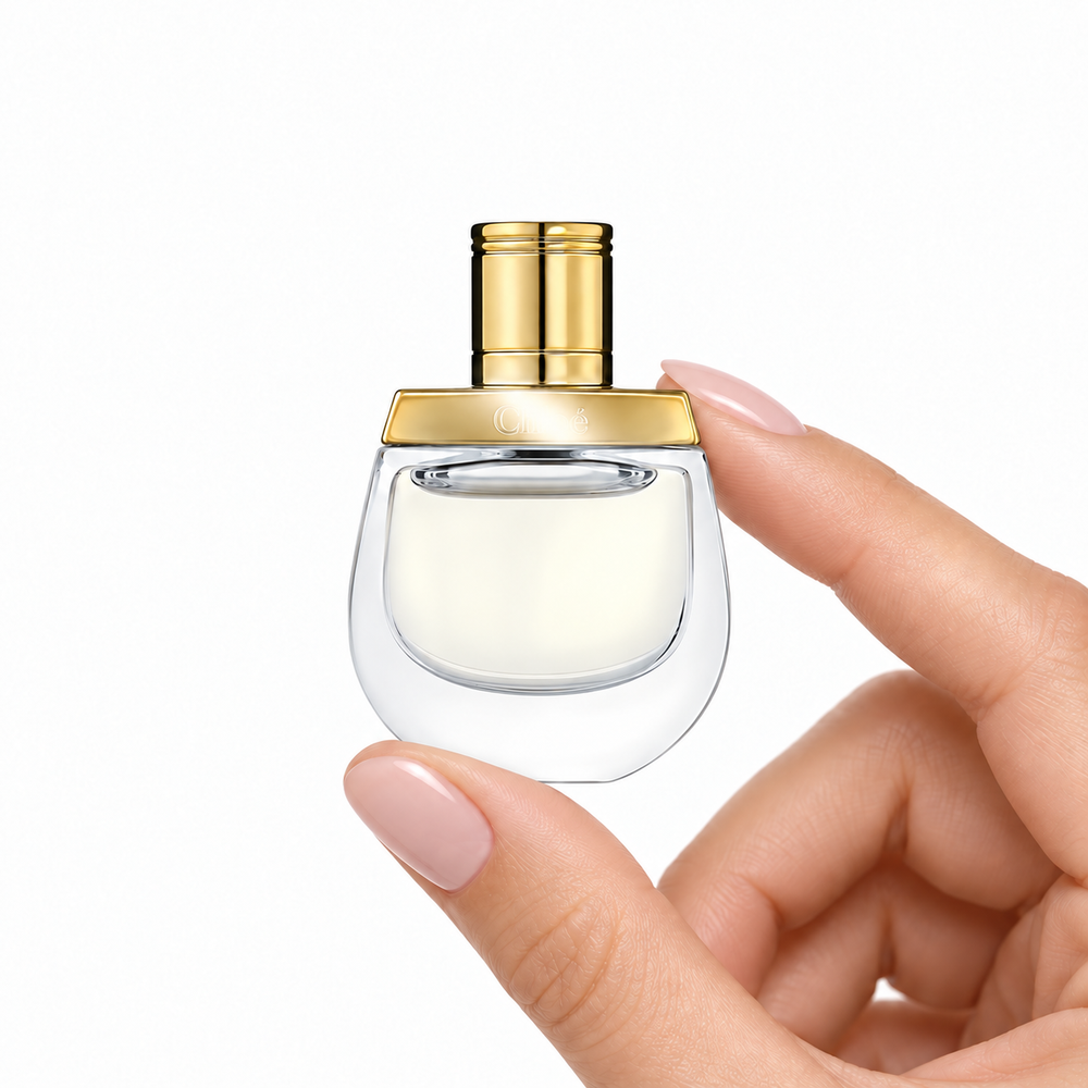 Golden Reverie 5ml miniature held between fingertips on white