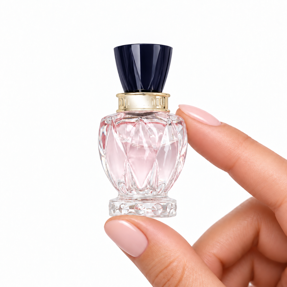 Blush Current 5ml miniature held between fingertips on white