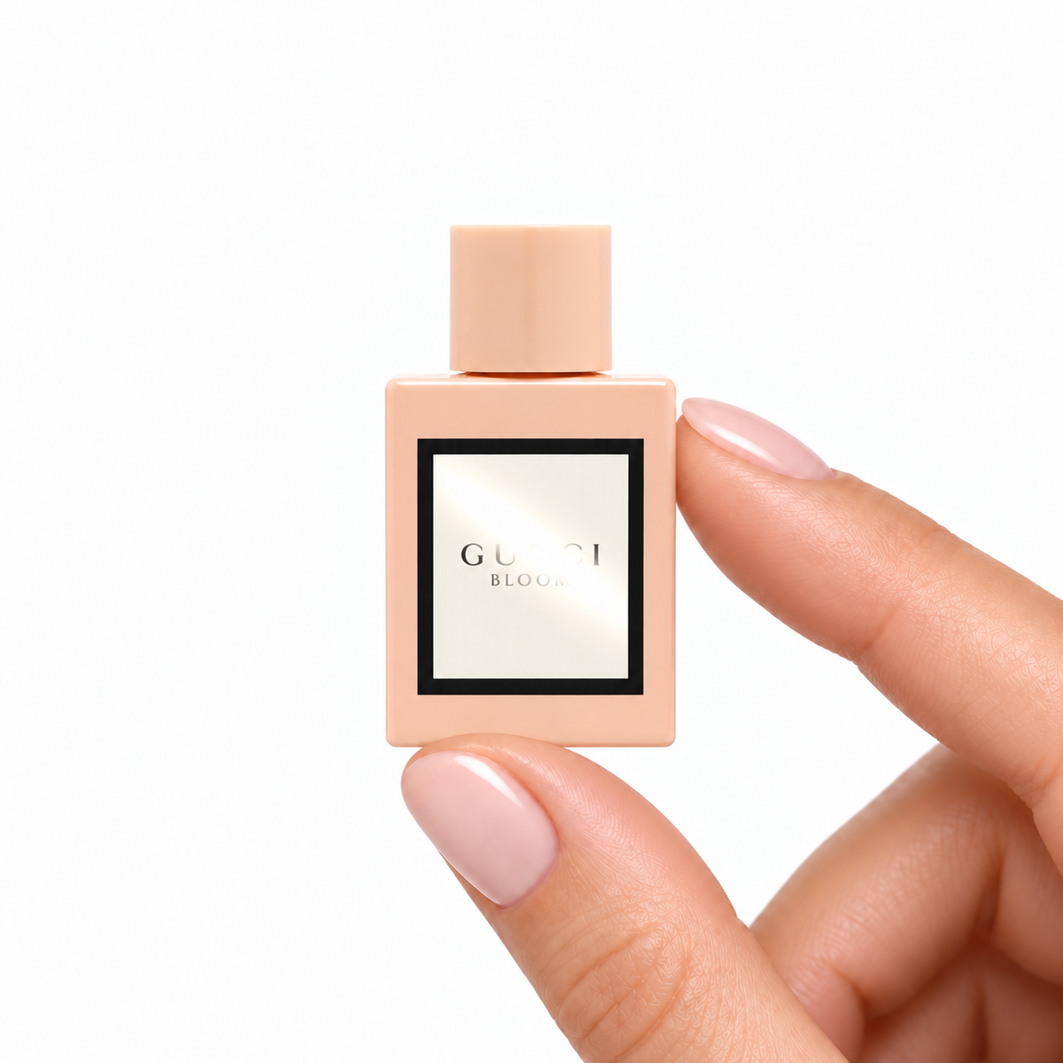 Jasmine Reverie 5ml miniature held between fingertips on white