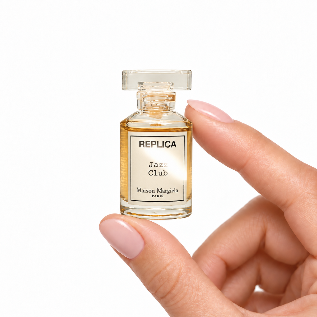 Afterdark Lounge miniature fragrance held between fingertips on white