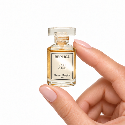 Afterdark Lounge miniature fragrance held between fingertips on white