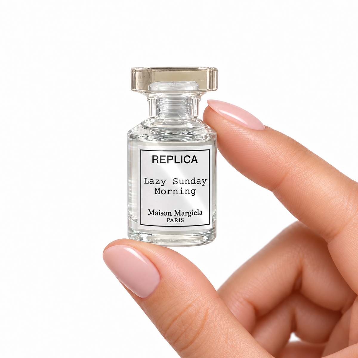 Sunday Linen miniature fragrance held between fingertips on white